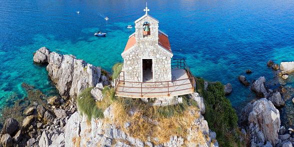 Aerial view of a beautiful church of Sveta Nedelja built on top of a small island in front of the town of Petrovac, Montenegro