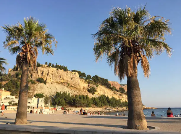 Photo of View of the Plage de la Grande Mer beach with Château de Cassis and Cap Canaille headland in the background on a summer sunny day in Cassis, located in the Provence-Alpes-Côte d'Azur region.