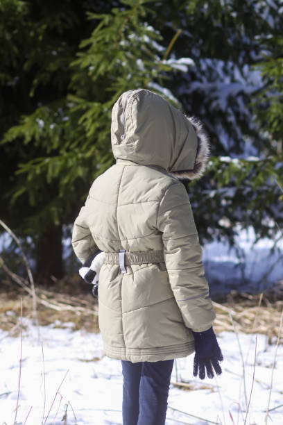 istock Little girl walking in snow-covered winter forest. 1332677110
