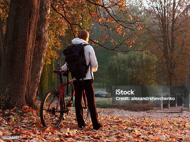 Donna Con Bici Ciclista E Zaino In Autunno Parco - Fotografie stock e altre immagini di Adulto - Adulto, Albero, Ambientazione esterna