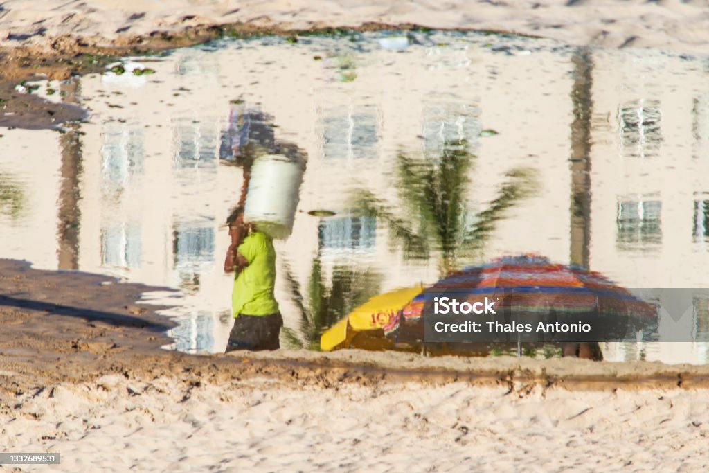 Reflection of a person in the puddle of water at Ondina beach. Beach Stock Photo