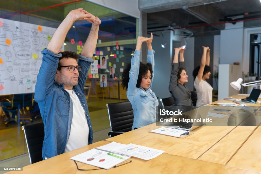 Arbeiter, die Dehnübungen in einem Geschäftstreffen im Büro durchführen - Lizenzfrei Wohlbefinden Stock-Foto