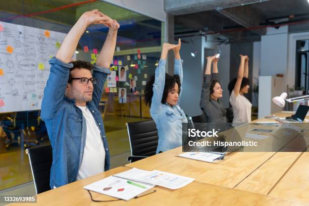 Workers Doing Stretching Exercises In A Business Meeting At The Office Stock Photo - Download Image Now
