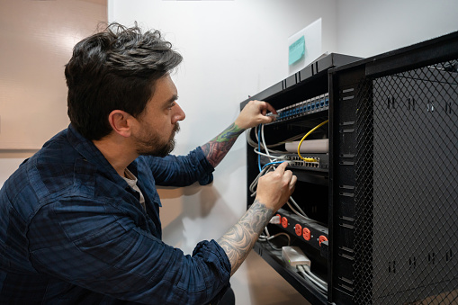 IT support worker connecting a wifi service at an office building - technology concepts