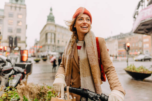 Running errands on my bicycle Photo of a smiling young woman running errands on her bicycle all over the city tourist stock pictures, royalty-free photos & images