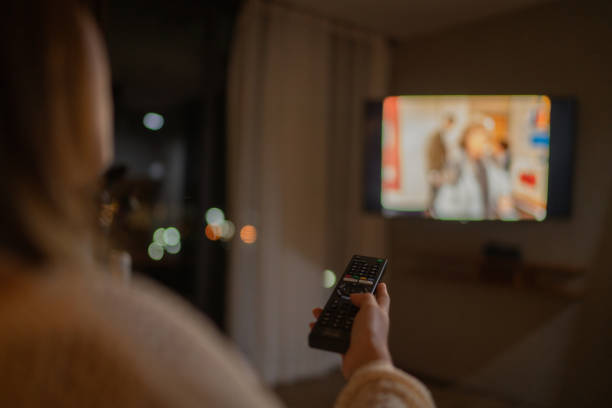 istock Happy woman enjoying watching television at night. 1332704456