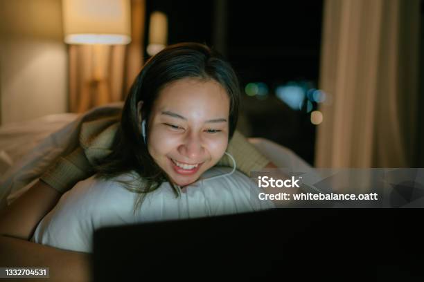 Asian Woman Relaxing On Friday Night At Her Apartment Watching A Movie On Tv Enjoying A Night In Bed Stock Photo - Download Image Now