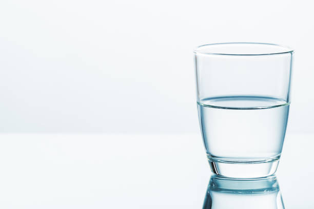 Half Empty, Half Full Glass A glass of half water on clear white background, half full or half empty, contradictory attitude and point of view pessimism photos stock pictures, royalty-free photos & images