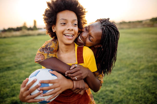 We like to be competitive Mother and daughter playing on filed with ball pre adolescent child stock pictures, royalty-free photos & images