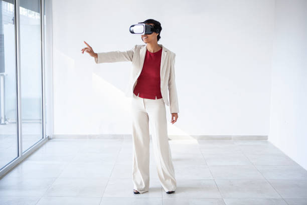 Latin woman in a formalwear using virtual reality glasses stock photo