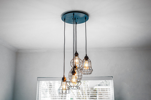 Industrial style metal and glass hanging pendant light in eat in kitchen