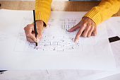 Young adult latin architect working on blueprint