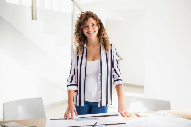 istock Young latin architect standing behind desk while smiling at the camera 1332708255