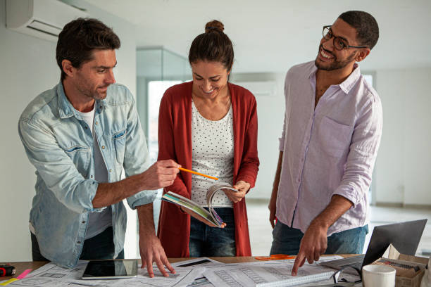 istock Multi ethnic group of architects and designers working on blueprints inside office 1332708460