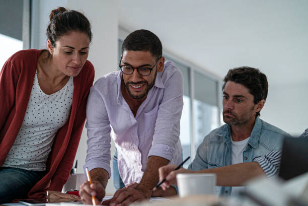 istock Multi ethnic group of architects and designers working on project together 1332708503