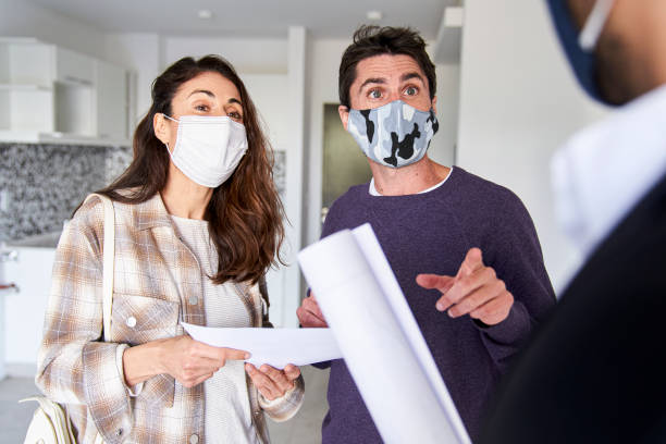 istock Mid adult couple going over rent contract details while wearing facemasks 1332709561