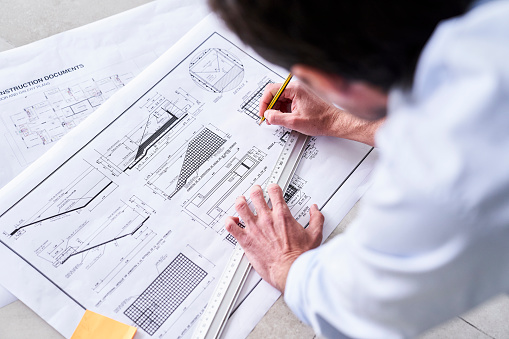 Close up of mid adult architect man working on home renovations sketches