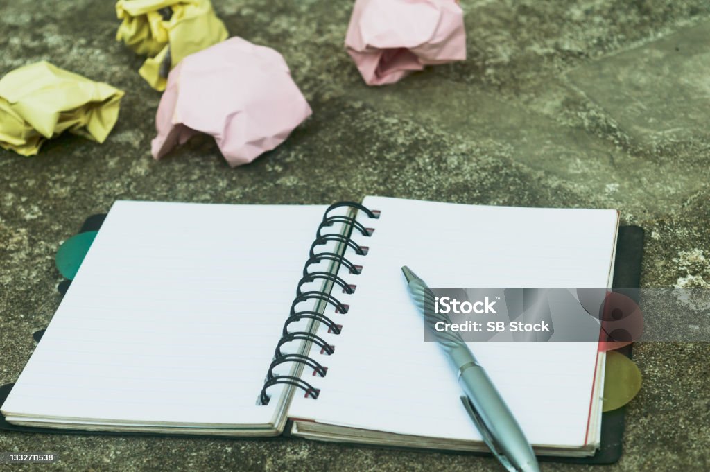 Notebook pen and crumpled paper on rustic floor. Mistake Learning, wrong, blooper, error, regret sayings background. Feelings, apology, message, love, in relationship friendship concept. Flat Lay Accuracy Stock Photo