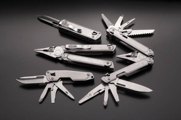 istock Folding multitools and knives on a dark background. Metal pocket multi-tools. 1332714856