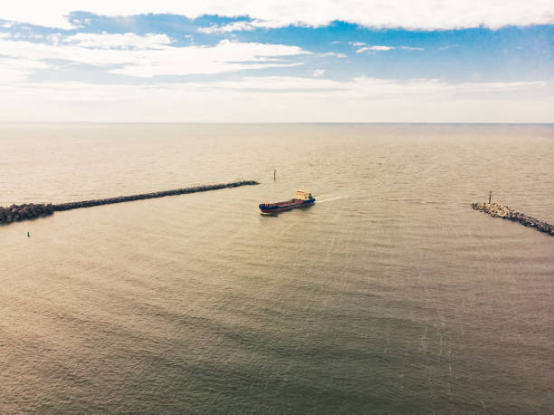 aerial panoramic view cargo ship entering klaipeda port in lithuania with vast sea background - klaipeda imagens e fotografias de stock