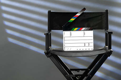 director's chair with clapperboard on gray background of photo studio
