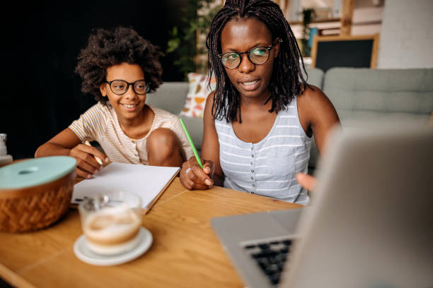 istock Mother and daughter studying online at home 1332720443