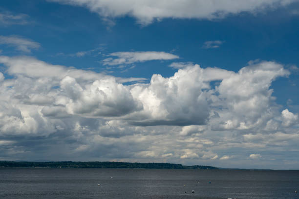 Puget Sound from Edmonds, Washington, on summer day Puget Sound, in Washington state, is seen from the beach in Edmonds, near Seattle. A summer day with blue sky and many cumulus clouds. edmonds stock pictures, royalty-free photos & images