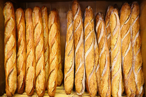 Freshly baked French baguette breads displayed in vertical rows