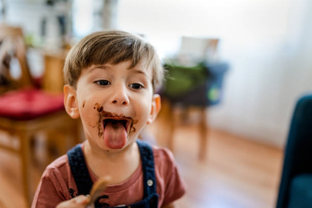 cute little boy enjoy eating ice cream at home - jongen peuter eten stockfoto's en -beelden