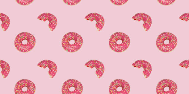 istock Bright rose background with a bitten and whole doughnut. 1332728473