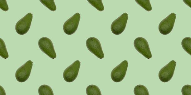 istock Green whole avocado on the green background. 1332728497