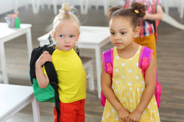 students friends with school backpacks on their backs came to the classroom for lessons