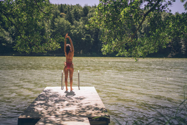 She stretches and looks off towards forested coastline in the distance