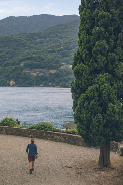 He looks off towards forested coastline in the distance