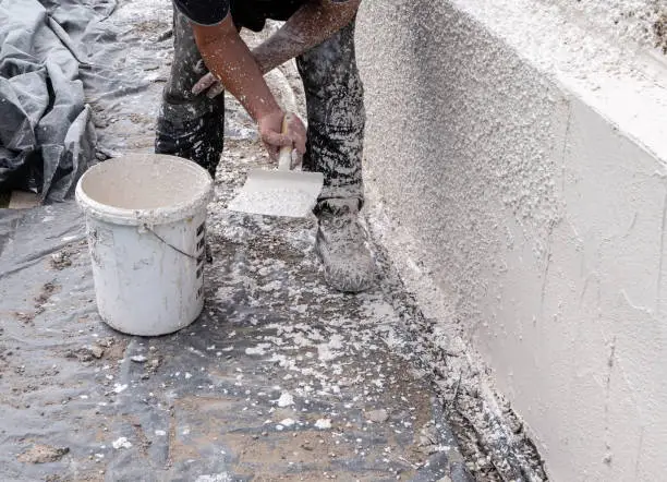 Photo of Rough-cast harling mix being put on an external wall