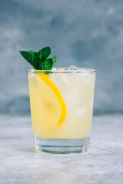 istock Ice lemonade in glass with lemon pieces, fresh mint and ice cubes. 1332734455