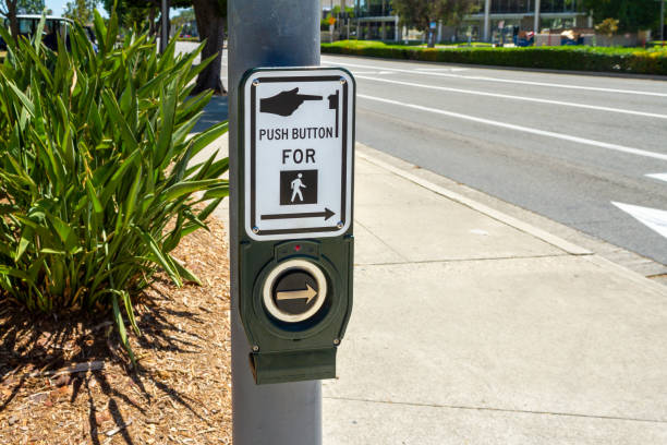 dispositivo pulsante crosswalk su un palo della strada - push button foto e immagini stock
