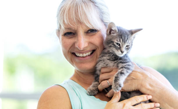 istock Mature woman holding kitten, smiling 1332737539