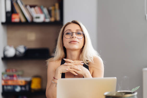 istock Young woman wearing glasses sit at desk watch webinar making notes 1332740701