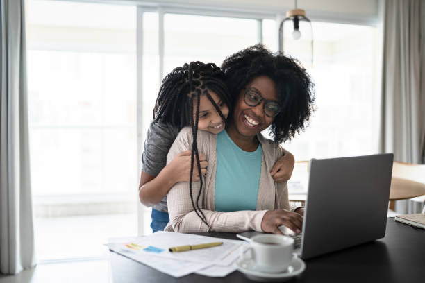 istock Girl embracing mother while she's working at home 1332741413