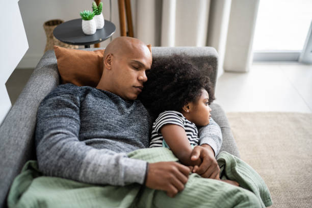istock Father and daughter napping on the couch at home 1332741440