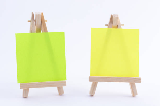 istock Two Wooden Easels Miniature with Blank Colored Square Canvas or Memo Paper 1332741493