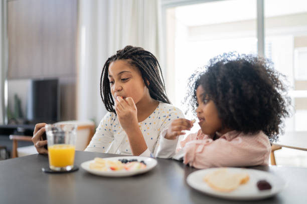 istock Sisters having breakfast and using smartphone together at home 1332742122