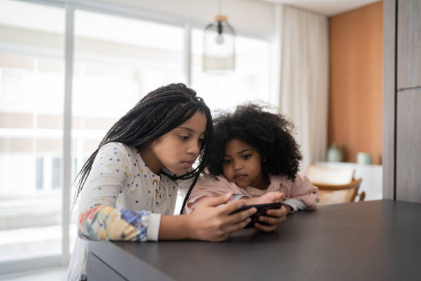 istock Sisters watching something on smartphone at home 1332742177