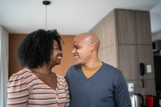 istock Happy couple smiling while looking at each other at home 1332742201