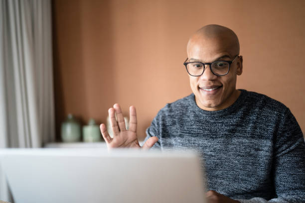 istock Man doing a video call on laptop at home 1332742858