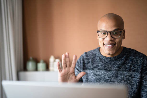 istock Man doing a video call on laptop at home 1332742864