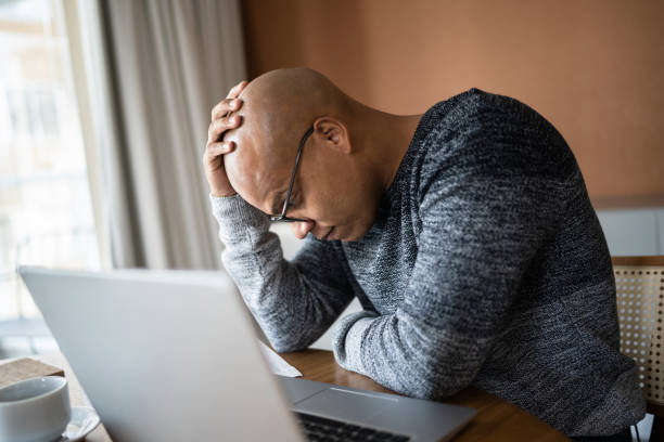 Worried man using laptop working at home