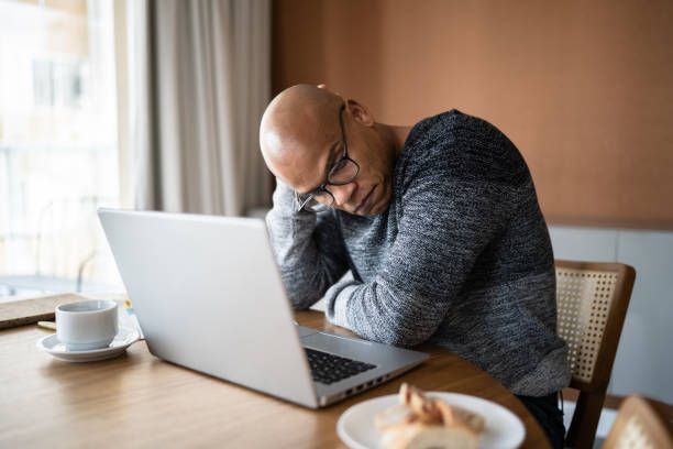 istock Worried man using laptop working at home 1332742895