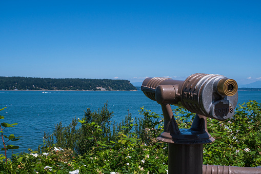 Image shows an observation telescope pointed at Penn Cove.  Penn Cove is part of Puget Sound and is famous for the oysters and mussels farmed there.